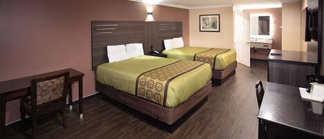 A hotel room with two beds, a desk, a chair, and a TV.