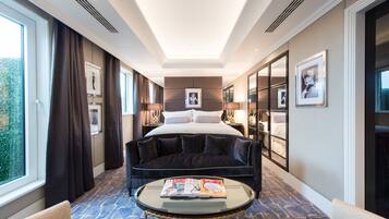 Une chambre d’hôtel avec un grand lit, un canapé, une table basse et une vue sur l’extérieur.