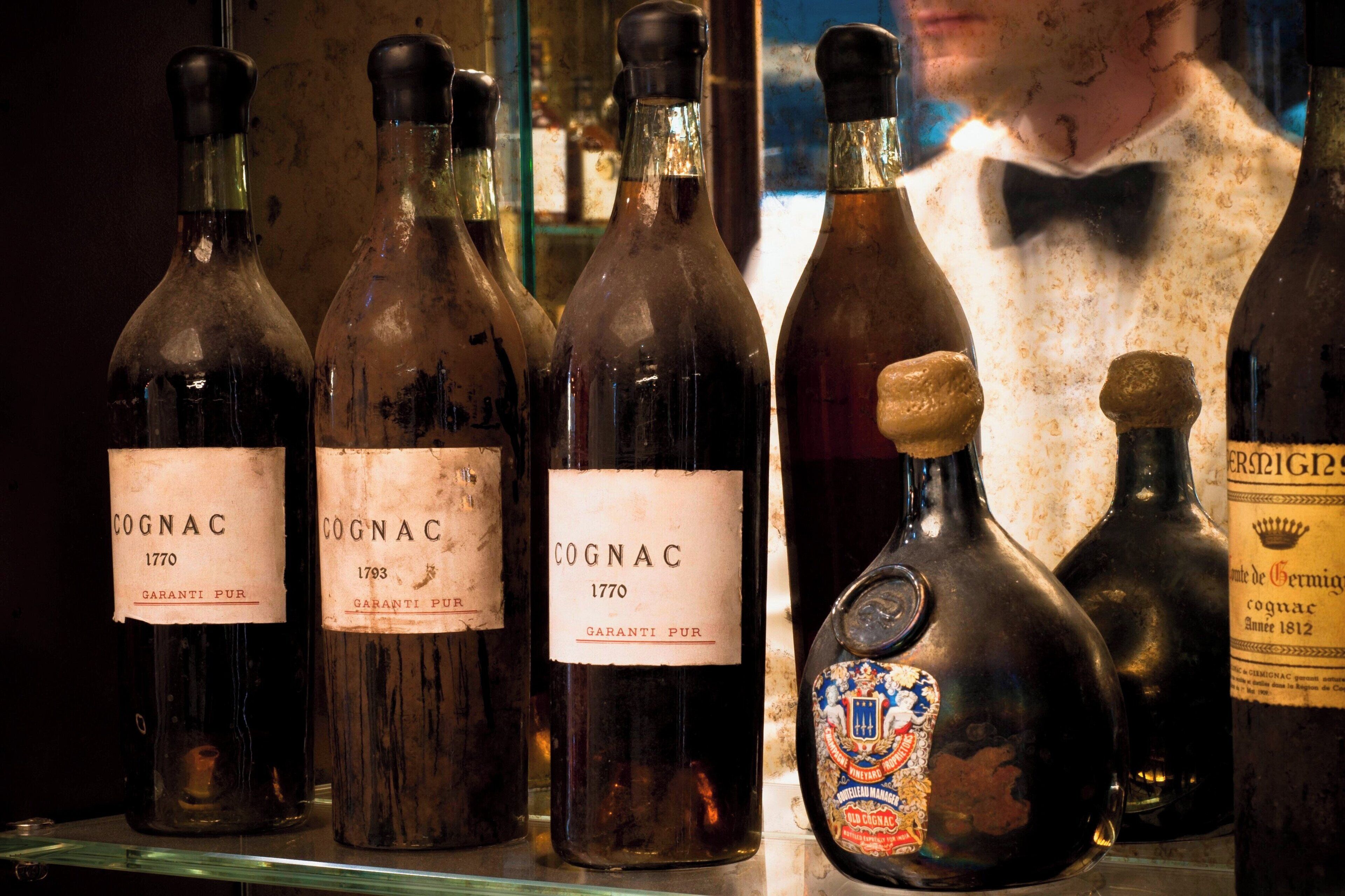 A collection of vintage Cognac bottles on display.