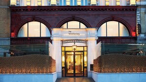 Hotellin sisäänkäynti, jossa on näyttävä kaarimainen oviaukko, kyltti, jossa lukee ”The Wellesley”, ja koristeellinen valaisin oven yläpuolella.
