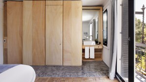 Une chambre moderne dotée d’une grande armoire, d’un lavabo intégré et d’une grande fenêtre donnant sur l’extérieur.