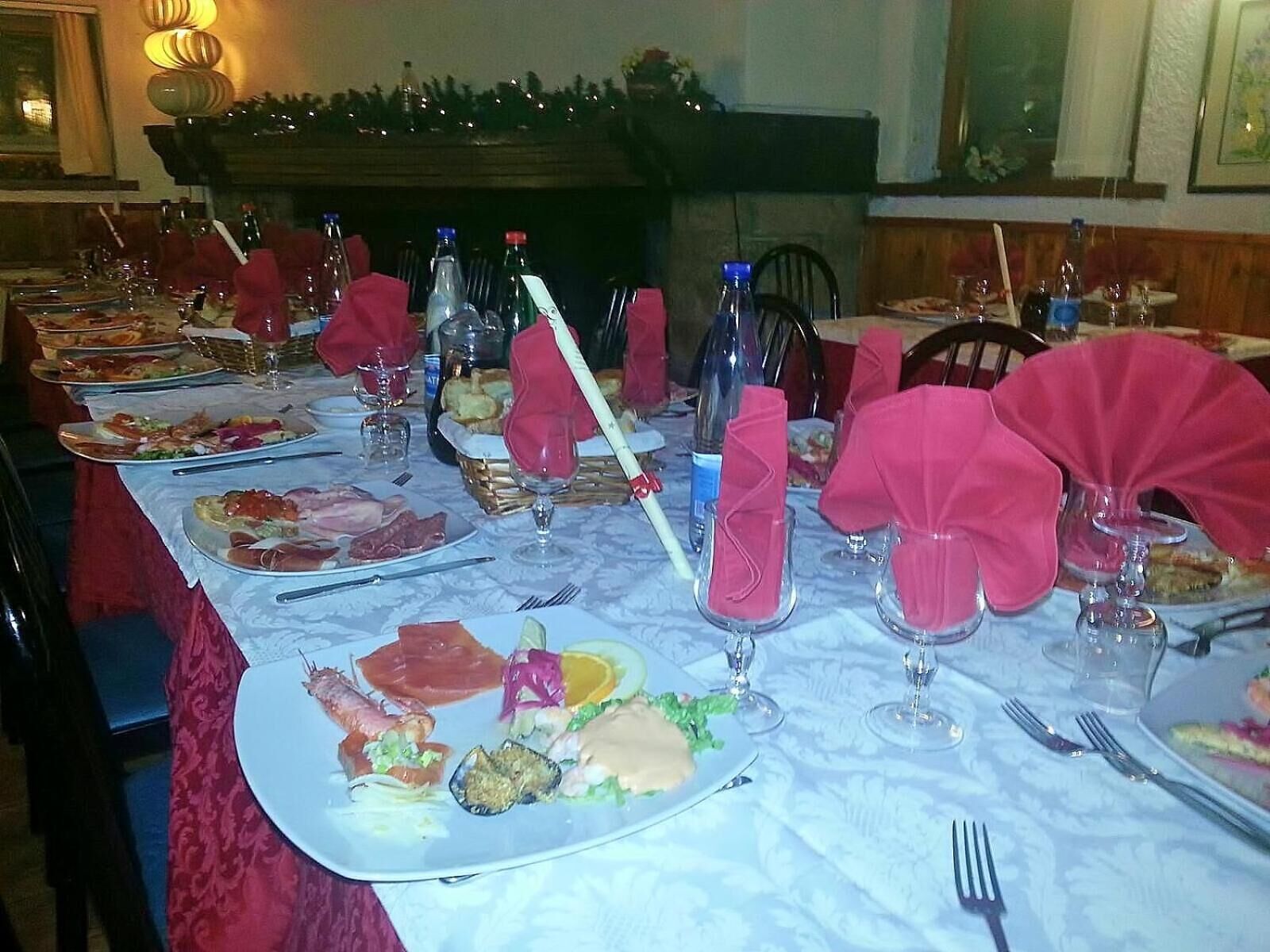 A dining table set with various dishes, glasses, and cutlery, with a fireplace in the background.