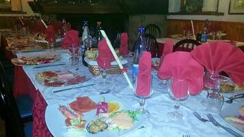 A dining table set with various dishes, glasses, and cutlery, with a fireplace in the background.