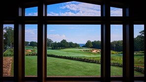 A view of a golf course through large windows.