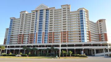 A multi-story hotel with a central atrium, balconies, and a parking garage.