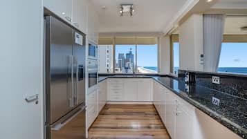 4.5 Star Beachfront Apartment | Cocina privada | Frigorífico, microondas, placa de cocina y lavavajillas