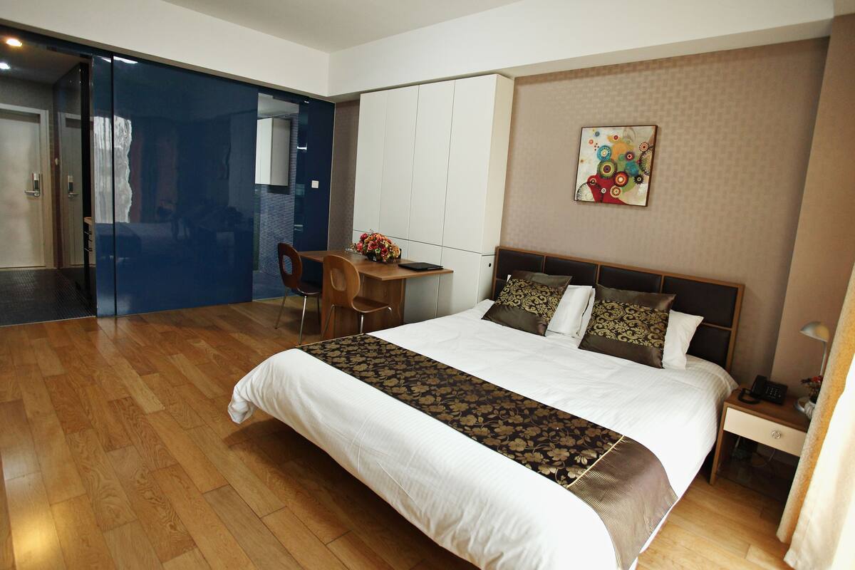 Een hotelkamer met een groot bed, een bureau, een stoel en een kledingkast.