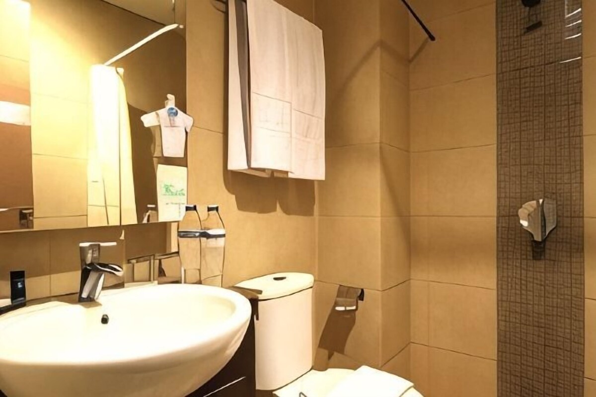 A bathroom with a sink, mirror, towel rack, and shower.