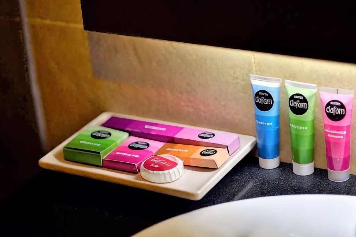A bathroom with a sink, a tray of toiletries, and three tubes of lotion.