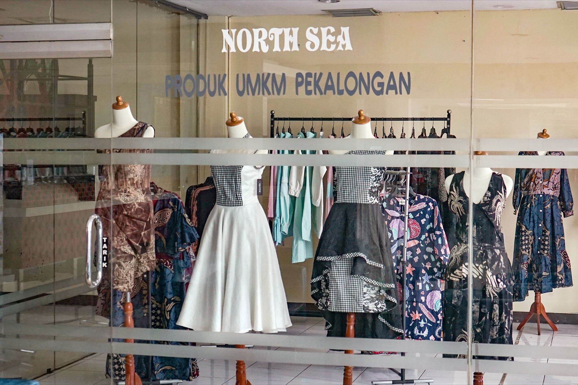 A clothing store with a sign reading "NORTH SEA PRODUK UMKM PEKALONGAN".