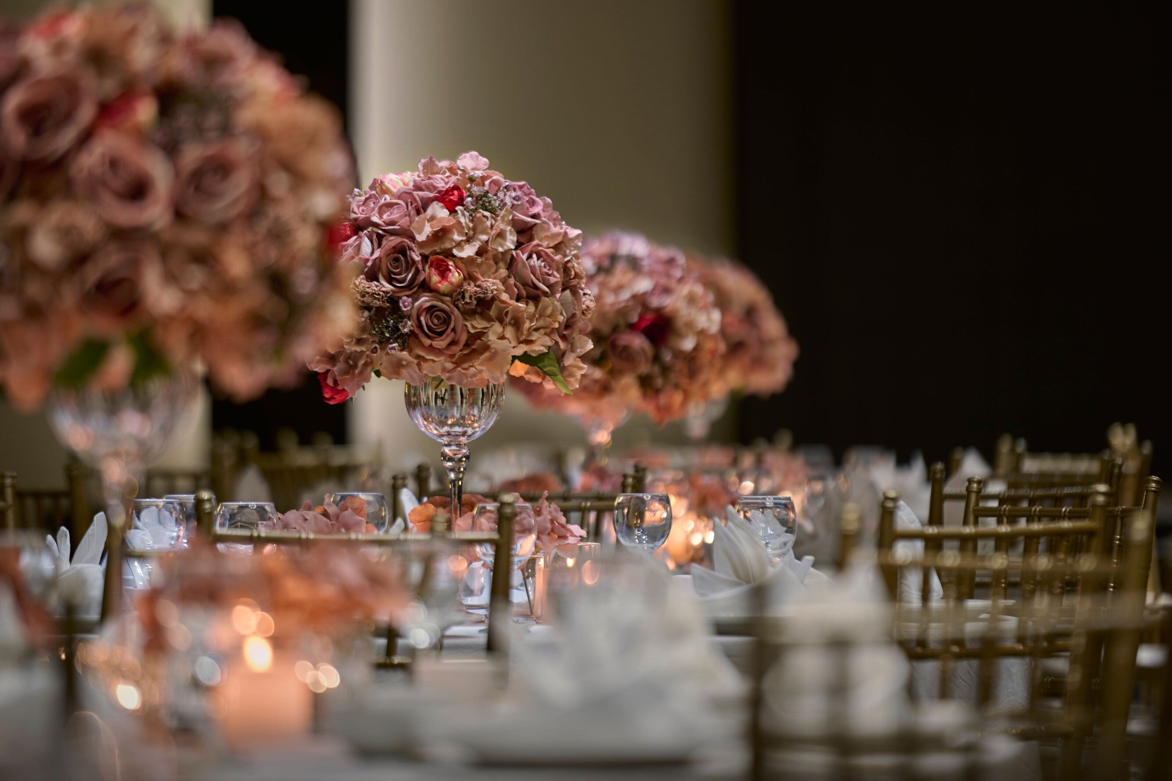 A table set for a formal event with floral centerpieces and candlelight.