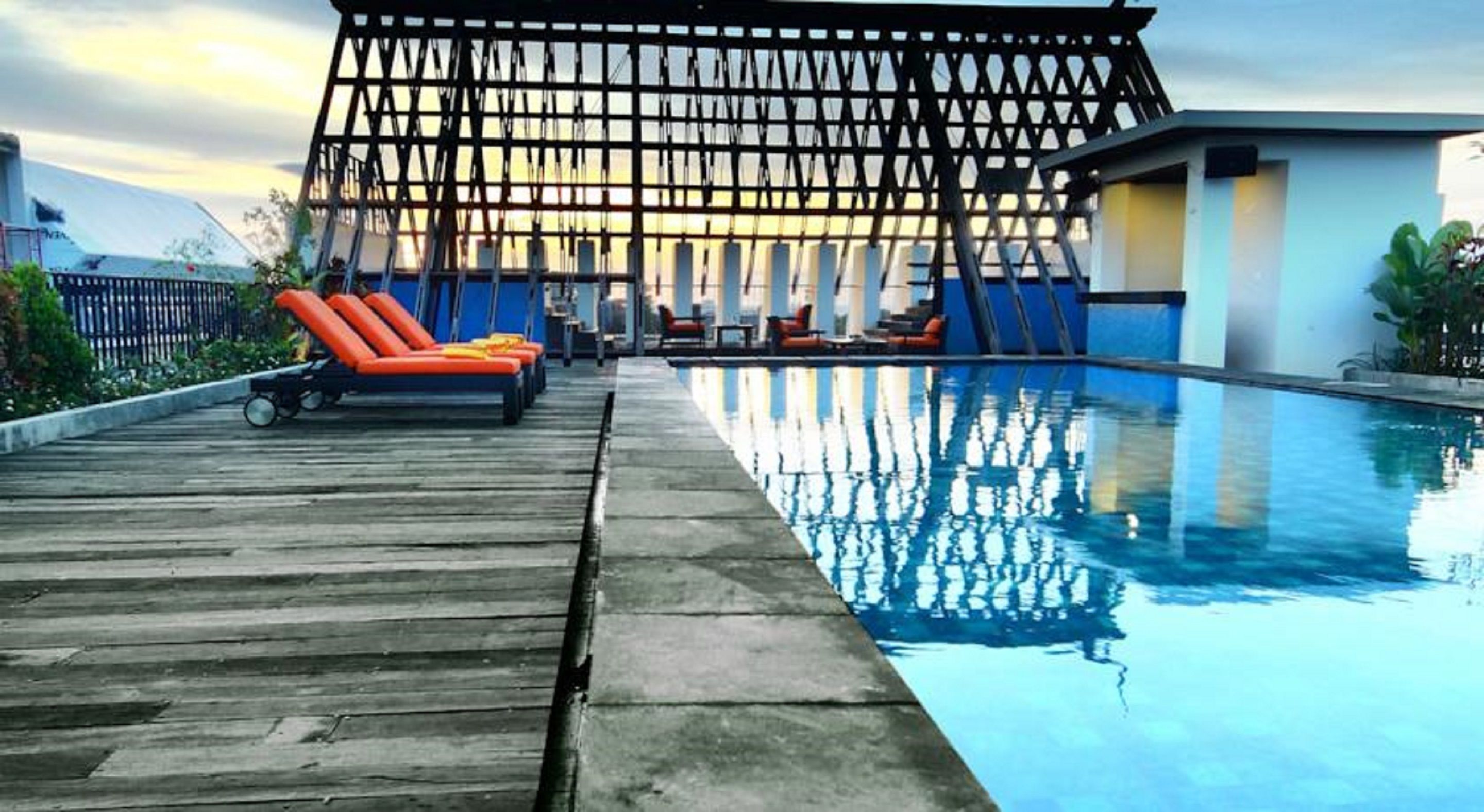 A pool area with lounge chairs and a wooden deck.