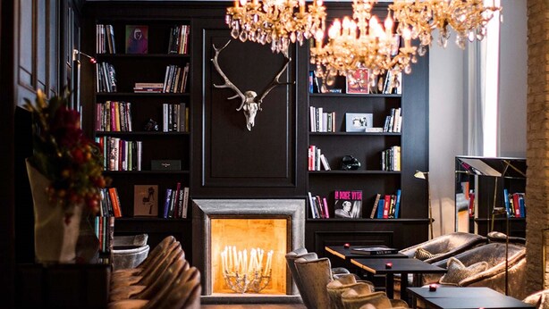 A cozy reading area with bookshelves, a fireplace, and comfortable seating. - DOM Hotel (Rome)