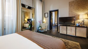 A hotel room with a bed, a TV, a desk, and a lamp. - DOM Hotel (Rome)