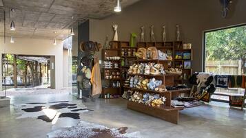 A store interior with shelves of various items, a central display of stuffed animals, and a cowhide rug on the floor.