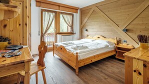 A wooden bedroom with a bed, a desk, and a chair. - Nord Hotel (Cortina d'Ampezzo)