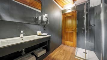 Een moderne badkamer met een groot wastafel, spiegel en douche met glazen wanden.