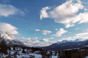 Un pueblo cubierto de nieve en la montaña, con edificios tradicionales y un cielo despejado.