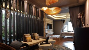 Een moderne woonkamer met een bank, twee bijzettafels, een grote geweven lamp en uitzicht op de omgeving.