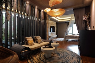 Een moderne woonkamer met een bank, twee bijzettafels, een grote geweven lamp en uitzicht op de omgeving.