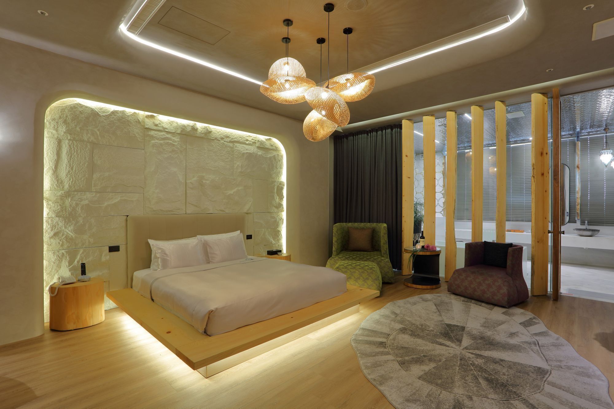 A modern bedroom with a large bed, a unique textured wall, and a contemporary chandelier.