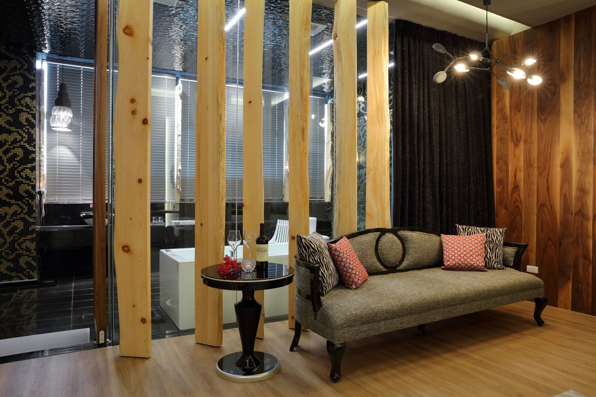 A modern living room with a sofa, a round table, and a wooden partition.