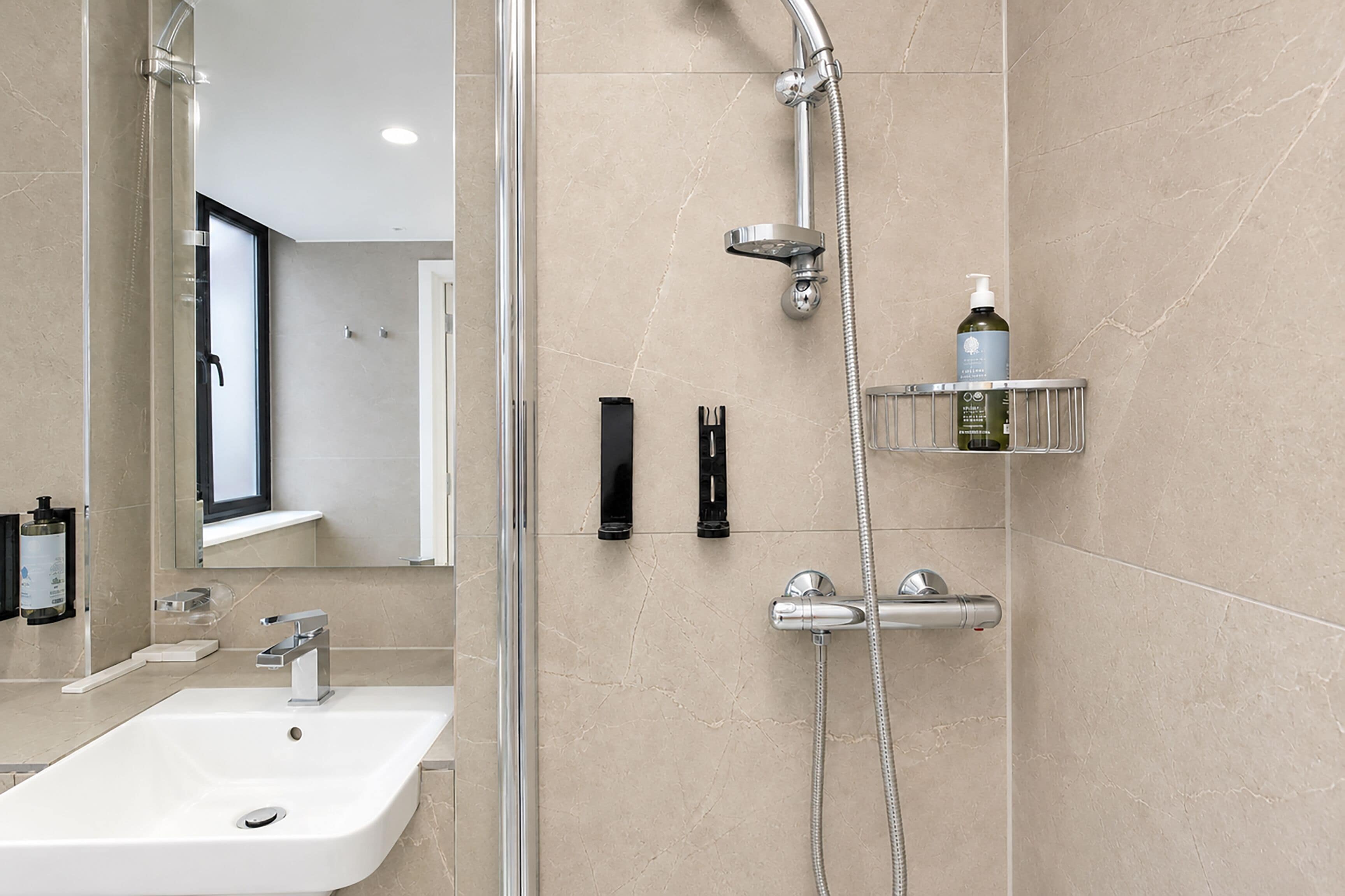 A modern bathroom with a shower, sink, and a mirror.