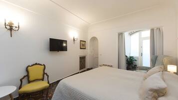 Une chambre d’hôtel avec un grand lit, une télévision, une chaise et une petite table.
