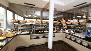 Un espace buffet proposant une variété de plats, des plateaux de service et un sol en marbre.