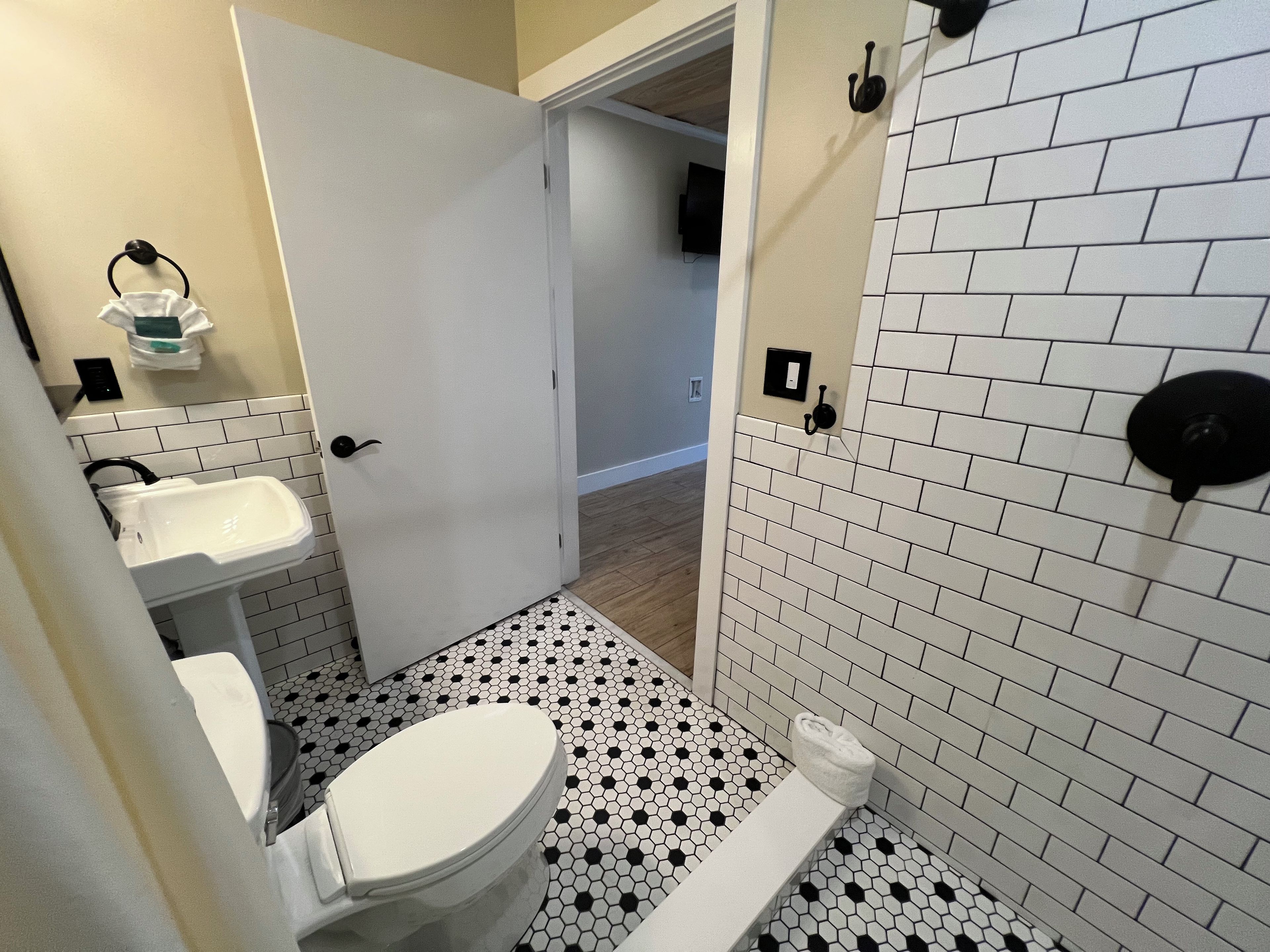 A bathroom with a toilet, sink, and a towel rack.