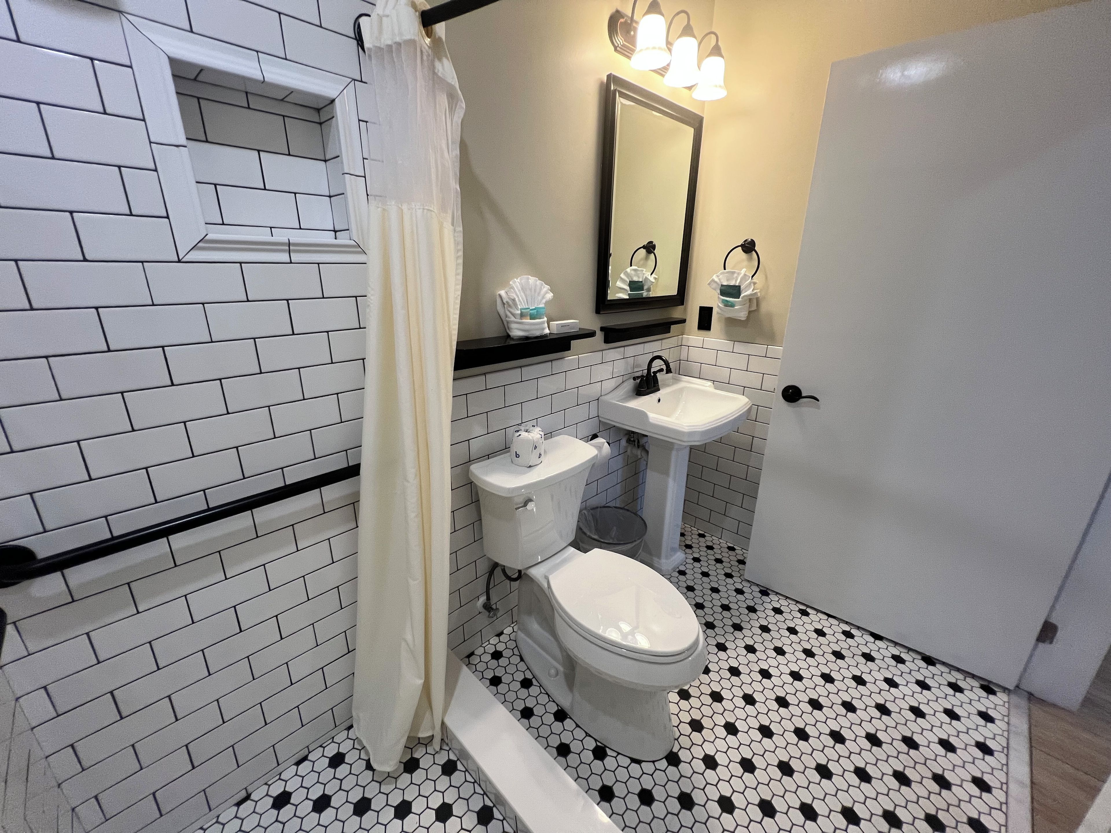A bathroom with a toilet, sink, and mirror.