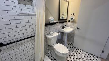 A bathroom with a toilet, sink, and mirror.