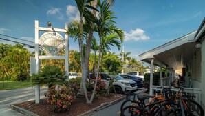 A motel sign, parked bicycles, and a building with a covered porch.
