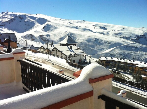 A snow-covered mountain with a ski resort in the background.