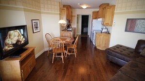 A compact living space with a dining area, kitchenette, and a seating area.