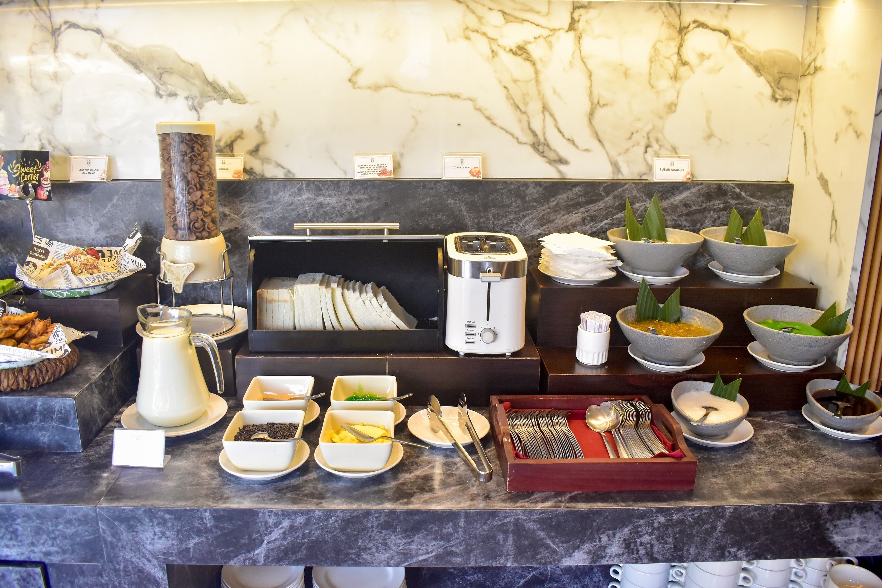 A breakfast buffet with various food items and a coffee machine.