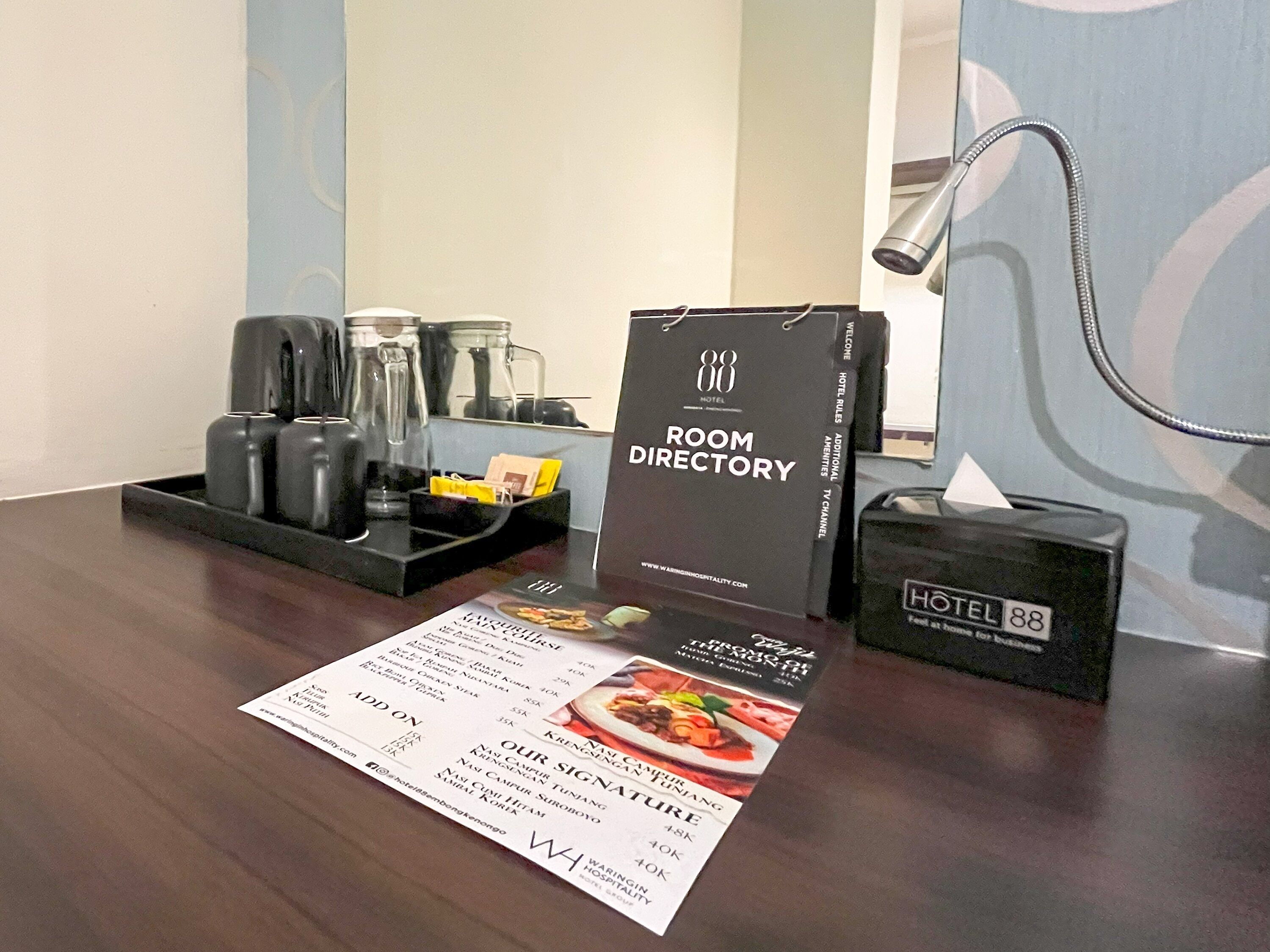 A hotel room with a room directory, a menu, and a minibar.