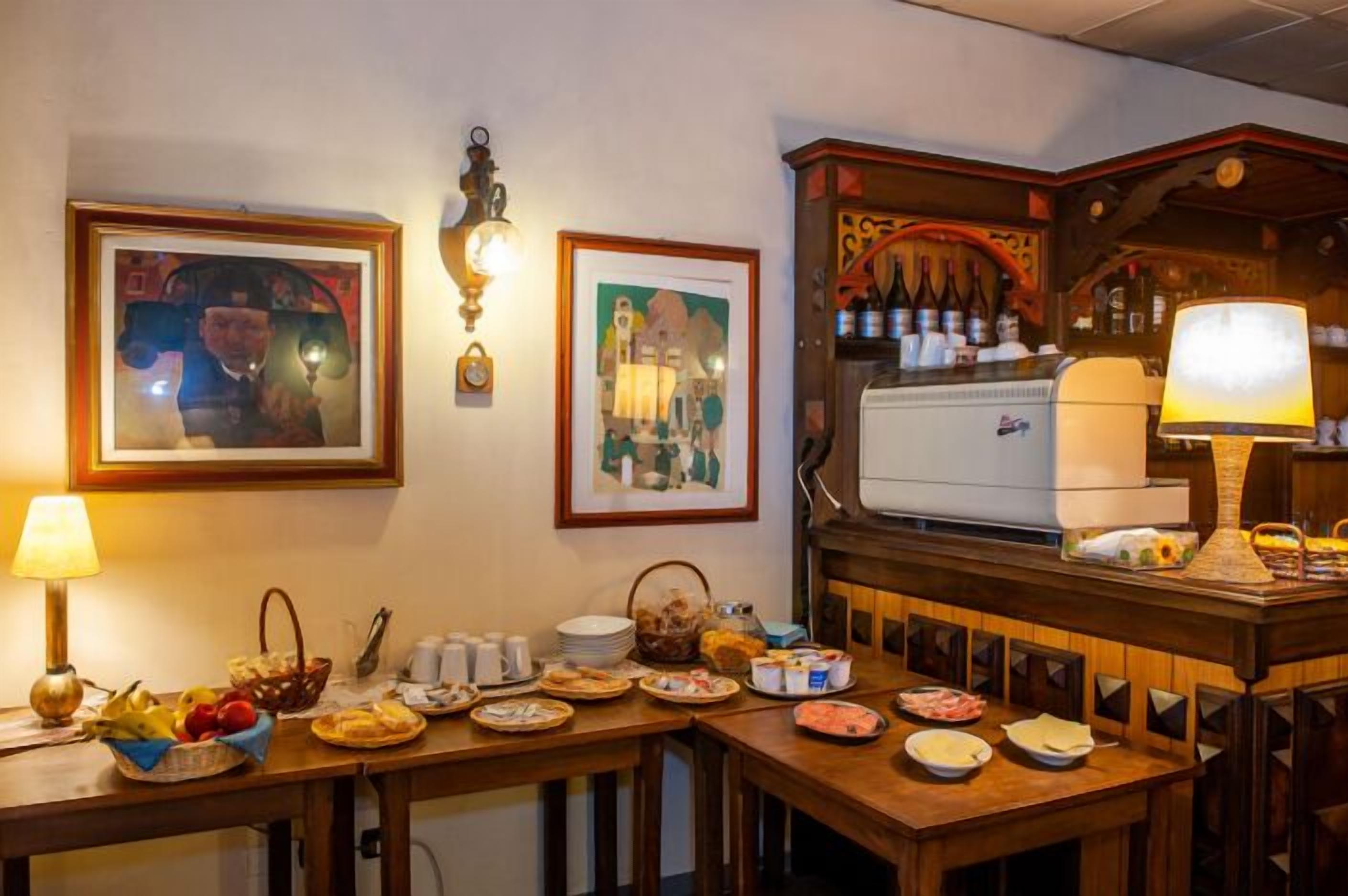 Angolo ristoro con buffet, opere d'arte appese alla parete e una cantina per il vino.