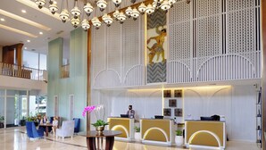 A hotel lobby with a reception desk, seating area, and decorative elements.