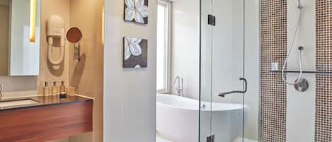 A modern bathroom with a glass shower enclosure, a freestanding bathtub, and a vanity with a wooden countertop.
