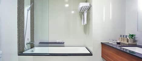 A modern bathroom with a glass-enclosed shower, a freestanding bathtub, and a wooden vanity with a sink.