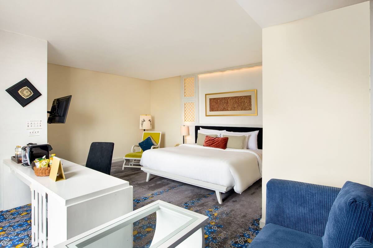 Une chambre d’hôtel avec un lit, un bureau, une chaise et un canapé.