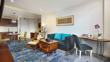 A modern living room with a sofa, chairs, a coffee table, and a dining area with a table and chairs.