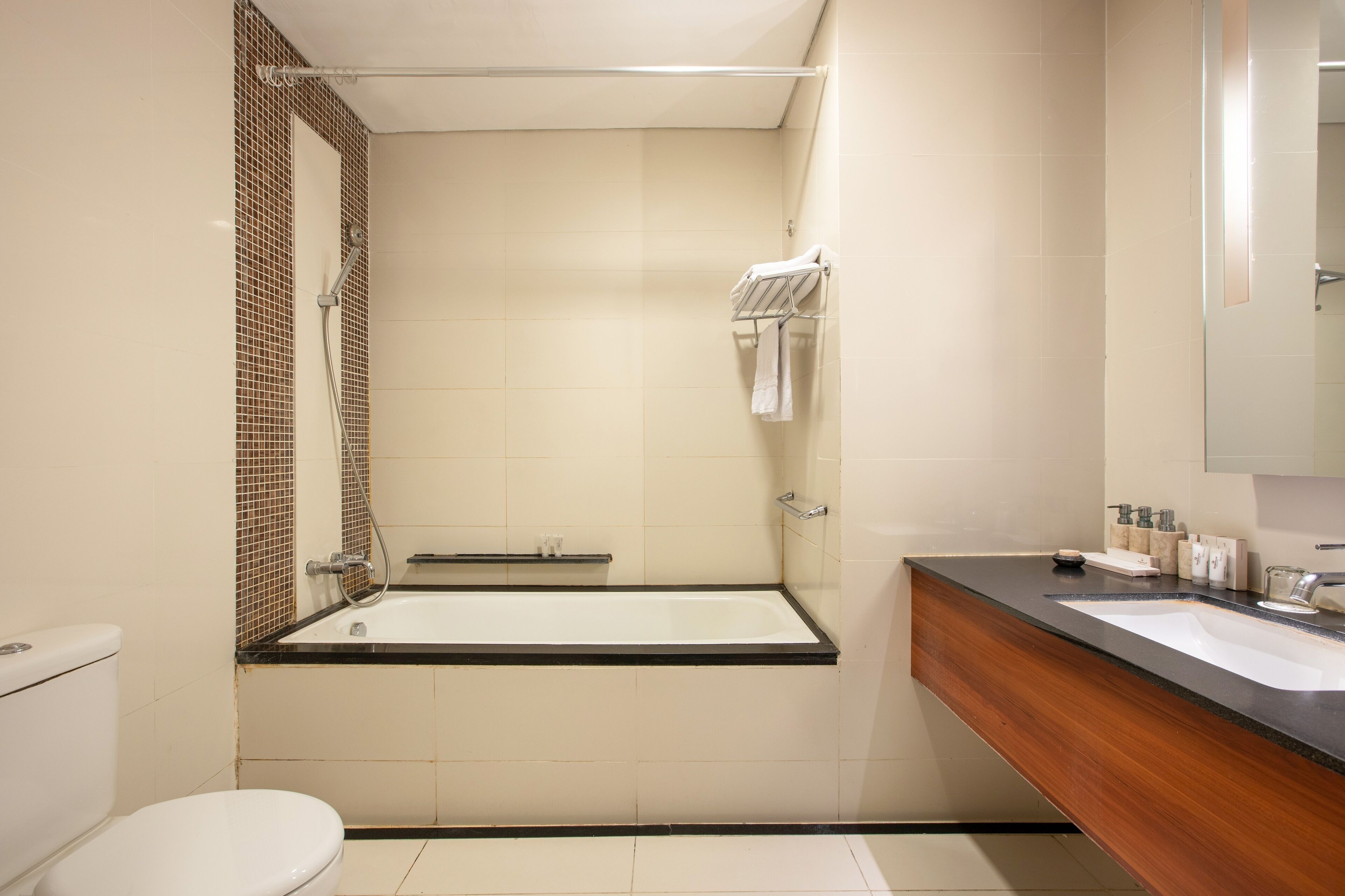 A modern bathroom with a bathtub, toilet, and vanity.