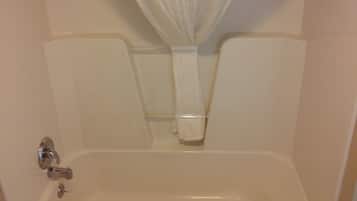 Un baño con bañera, cortina de ducha y barra para toallas.