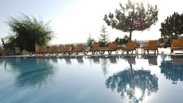 Piscine couverte, piscine extérieure, parasols de plage, chaises longues