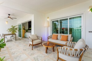 A modern living room with a sofa, chairs, a coffee table, and a dining table. - Aventuras Club (Puerto Aventuras)