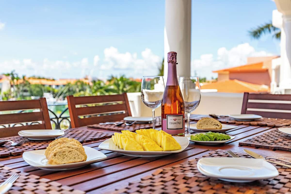 Une table dressée avec des assiettes remplies de nourriture, une bouteille de vin et des verres, offrant une vue panoramique.