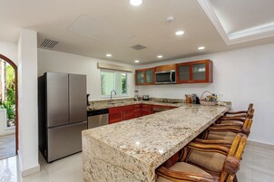 Una cocina moderna con encimera de granito, electrodomésticos de acero inoxidable y armarios de madera.