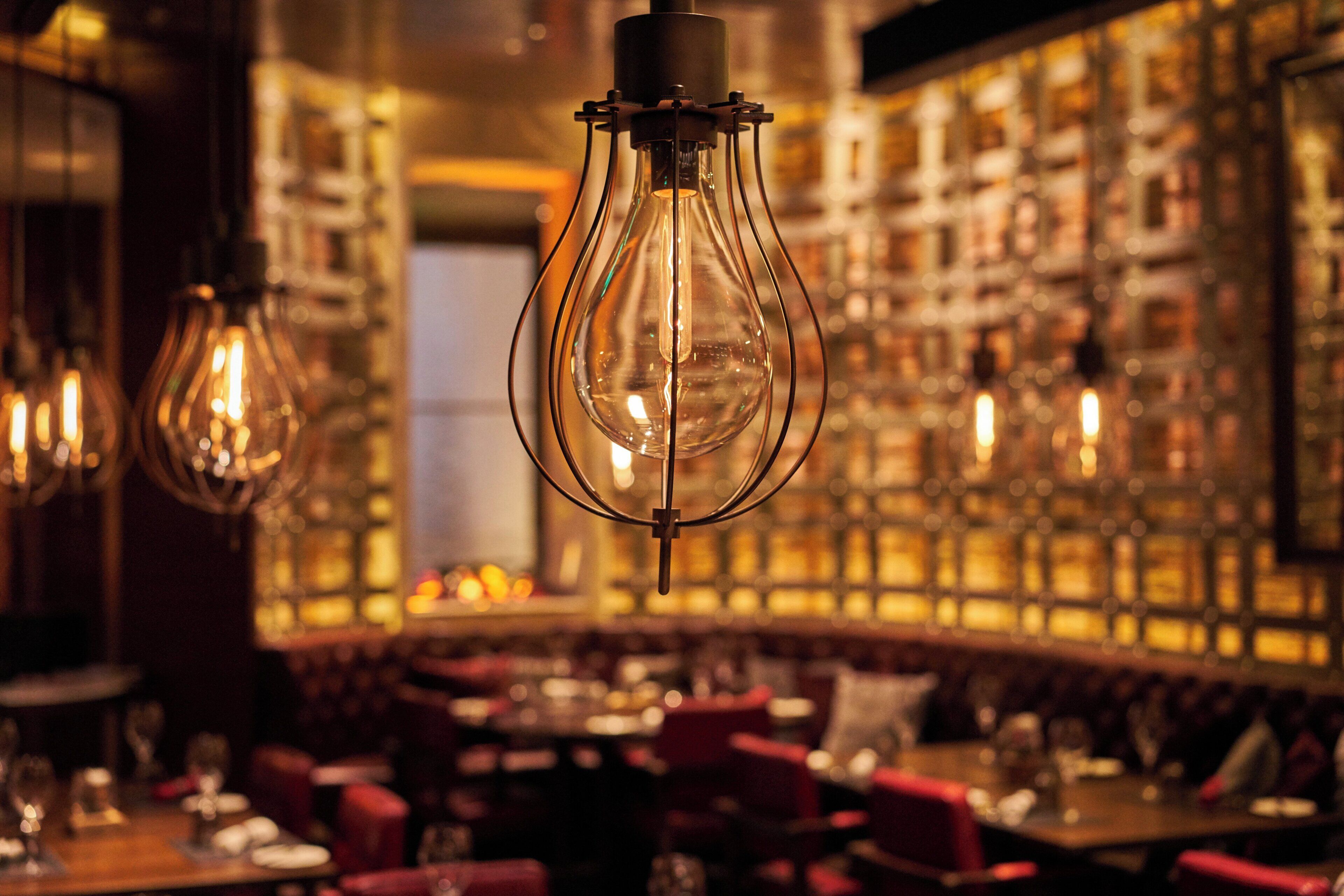 A bar area with hanging light fixtures and a bar counter.